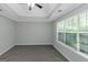 Spacious primary bedroom with tray ceilings, a ceiling fan, and a large window at 100 Hugh Dr, Covington, GA 30016