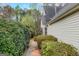 Side view of the home features manicured hedges and neutral vinyl siding and trim at 100 Hugh Dr, Covington, GA 30016