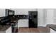 Galley kitchen with black appliances, white cabinetry and dark granite countertops at 100 Hugh Dr, Covington, GA 30016