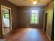 A spacious bedroom with hardwood floors, a window, and doorways to other rooms at 34 Pine St, Porterdale, GA 30014