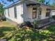 Cozy house with a covered porch surrounded by green yard and trees, creating a serene, vintage setting at 34 Pine St, Porterdale, GA 30014