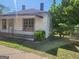 Charming single-story home with a covered porch, surrounded by a green lawn and trees for added privacy at 34 Pine St, Porterdale, GA 30014