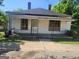 Quaint single-story home featuring a covered front porch, a simple yard, and a vintage charm at 34 Pine St, Porterdale, GA 30014