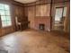 View of the living room with a fireplace, original wood floors, and piano at 34 Pine St, Porterdale, GA 30014