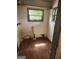 A small room with hardwood floors, a window, and pipes along the wall at 34 Pine St, Porterdale, GA 30014