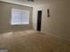 Bedroom featuring a window with blinds and bare floors at 10950 Wheeler Trce, Hampton, GA 30228