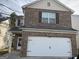 Two-story brick house with a white garage door and brown trim at 10950 Wheeler Trce, Hampton, GA 30228
