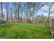 Expansive backyard with lush green grass and tall trees, offering privacy and space for outdoor activities at 2511 Due West Nw Cir, Kennesaw, GA 30152