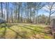 A spacious backyard with lush green grass, mature trees, and an outbuilding offers a serene outdoor retreat at 2511 Due West Nw Cir, Kennesaw, GA 30152