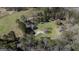 Aerial view of wooded property with house, out buildings, and pasture in the background at 689 Hardin Rd, Temple, GA 30179