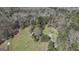Aerial view of the property surrounded by mature trees and a pond at 689 Hardin Rd, Temple, GA 30179