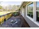 Relaxing back deck with a metal table set and a view of the surrounding yard and trees at 689 Hardin Rd, Temple, GA 30179