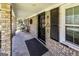 Charming front porch with brick facade, black door with triangle, and comfortable seating at 689 Hardin Rd, Temple, GA 30179