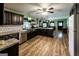 Modern kitchen with dark wood cabinetry, stainless steel appliances, farmhouse sink, and wood flooring at 689 Hardin Rd, Temple, GA 30179