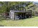 An outdoor shed with latticework and covered storage space, surrounded by trees and grass at 689 Hardin Rd, Temple, GA 30179