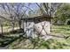 Small, well-maintained shed with a cross-buck door, nestled in a grassy yard with shade trees at 689 Hardin Rd, Temple, GA 30179