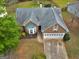 Aerial view of a brick home with a well-manicured lawn and a two-car garage at 105 Lantana Dr, Locust Grove, GA 30248