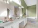 Bright bathroom features a large mirror, a double sink vanity, a soaking tub, and neutral wall colors at 105 Lantana Dr, Locust Grove, GA 30248
