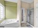 Bright bathroom with a large soaking tub, shower, and window with natural light at 105 Lantana Dr, Locust Grove, GA 30248