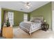 Spacious bedroom featuring a large bed, two windows, two side tables, and neutral wall colors at 105 Lantana Dr, Locust Grove, GA 30248