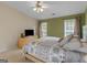 Spacious bedroom featuring a large bed, dresser, two windows, and neutral and green wall colors at 105 Lantana Dr, Locust Grove, GA 30248
