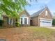 Brick home with large front yard, bay window and a two-car garage at 105 Lantana Dr, Locust Grove, GA 30248