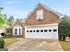 Charming brick home featuring a two-car garage and well-maintained front yard at 105 Lantana Dr, Locust Grove, GA 30248
