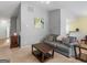 Inviting living room showcasing a gray sofa, coffee table, and seamless transition to dining area at 105 Lantana Dr, Locust Grove, GA 30248