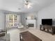 Bright living room featuring a fireplace, ceiling fan, comfortable furniture, and ample natural light at 105 Lantana Dr, Locust Grove, GA 30248