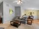 Open living room with a gray sofa, a wooden coffee table, and a view into the adjacent dining area at 105 Lantana Dr, Locust Grove, GA 30248