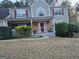Inviting two-story home showcasing a welcoming front porch and lush green landscaping at 888 Shadow Lakes Dr, Lithonia, GA 30058
