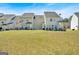 Spacious backyard view with lush green grass and multiple attached townhomes with outdoor patio areas at 7112 Brookview Way, Riverdale, GA 30274