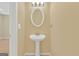 Half bathroom with pedestal sink, lighting fixture and an oval mirror at 7112 Brookview Way, Riverdale, GA 30274