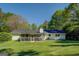 Backyard view of home with a screened-in porch and lush green lawn at 2340 Rolling Acres Sw Dr, Conyers, GA 30094