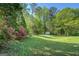 Expansive backyard featuring a lush lawn, mature trees, and a storage shed at 2340 Rolling Acres Sw Dr, Conyers, GA 30094
