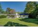 Backyard view of home with a screened-in porch and lush green lawn at 2340 Rolling Acres Sw Dr, Conyers, GA 30094