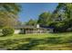 Backyard view of home with a screened-in porch and lush green lawn at 2340 Rolling Acres Sw Dr, Conyers, GA 30094