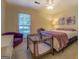 Bright bedroom with a plush purple chair, comfortable queen bed, and ceiling fan at 2340 Rolling Acres Sw Dr, Conyers, GA 30094