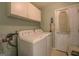 Practical laundry room equipped with washer, dryer, and overhead cabinets at 2340 Rolling Acres Sw Dr, Conyers, GA 30094