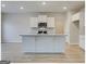Open kitchen with a large island, stainless steel appliances, and wooden flooring at 300 San Anselmo St, Locust Grove, GA 30248