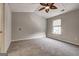 A bright bedroom with neutral carpet, ceiling fan, and a window offering natural light at 103 Watercress Ct, Stockbridge, GA 30281