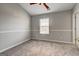 A bright bedroom with neutral carpet, ceiling fan, and a window offering natural light at 103 Watercress Ct, Stockbridge, GA 30281