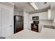 Kitchen featuring white cabinets, black appliances, and tile flooring at 103 Watercress Ct, Stockbridge, GA 30281