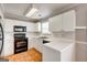 Kitchen features white cabinets, black appliances, and tile flooring at 103 Watercress Ct, Stockbridge, GA 30281