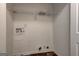 A small, utilitarian laundry room with hookups and a wire shelf ready for appliances and storage at 103 Watercress Ct, Stockbridge, GA 30281
