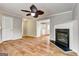Living room featuring hardwood floors, a ceiling fan, and a fireplace with a decorative mantel at 103 Watercress Ct, Stockbridge, GA 30281