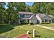 Home with green lawn, mature trees, driveway, and traditional architectural details at 131 Turning Pt, Stockbridge, GA 30281