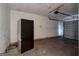 Spacious garage with a black refrigerator, exposed ceiling, and a door leading outside at 131 Turning Pt, Stockbridge, GA 30281