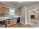View into kitchen with cabinets, stove, backsplash, and a doorway leading to the living room with fireplace at 131 Turning Pt, Stockbridge, GA 30281