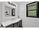 Bathroom features a modern vanity, decorative mirror, contemporary fixtures, and a bright window at 2451 Cedar Fork Trl, Marietta, GA 30062
